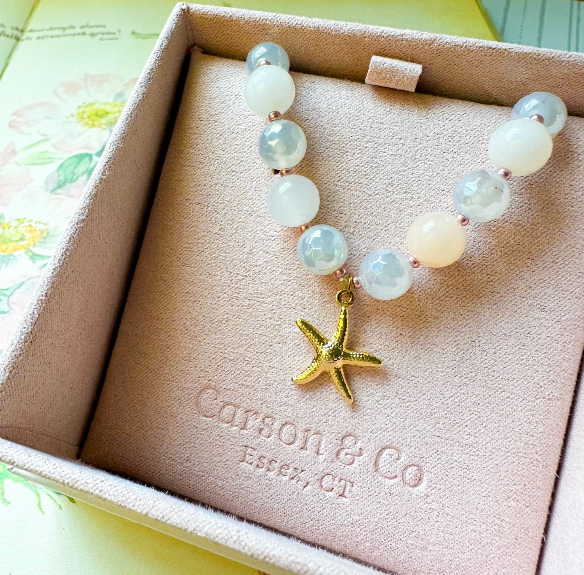 Bracelet with a starfish charm on a Carson & Co. box