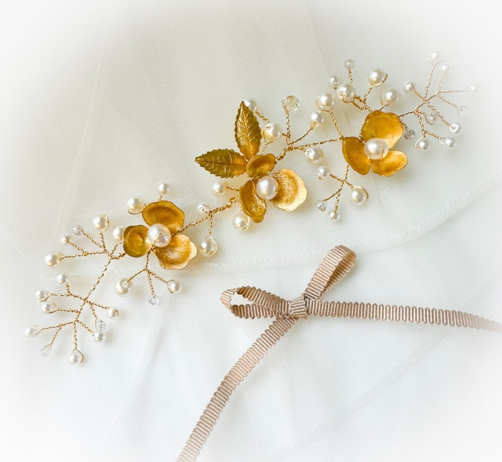 Gold floral hair accessories with pearls on a white background