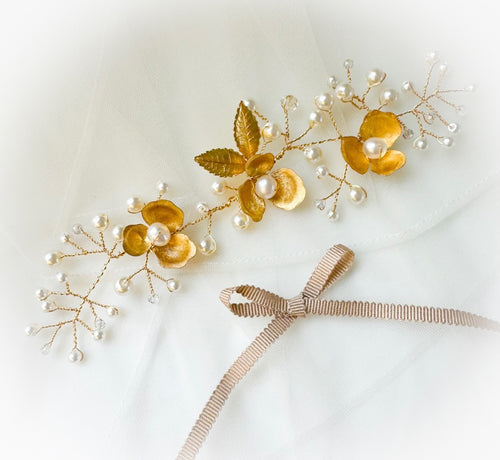 Gold floral hair accessories with pearls on a white background