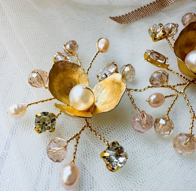 Gold and pearl brooch on a textured white background
