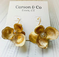 Gold flower-shaped earrings on a Carson & Co card