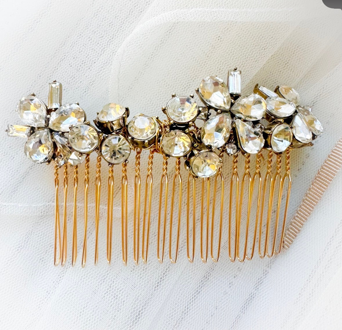 Gold hair comb with crystal embellishments on a white background