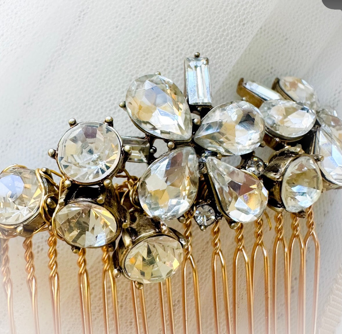 Gold hair comb with crystal-like stones on a white background