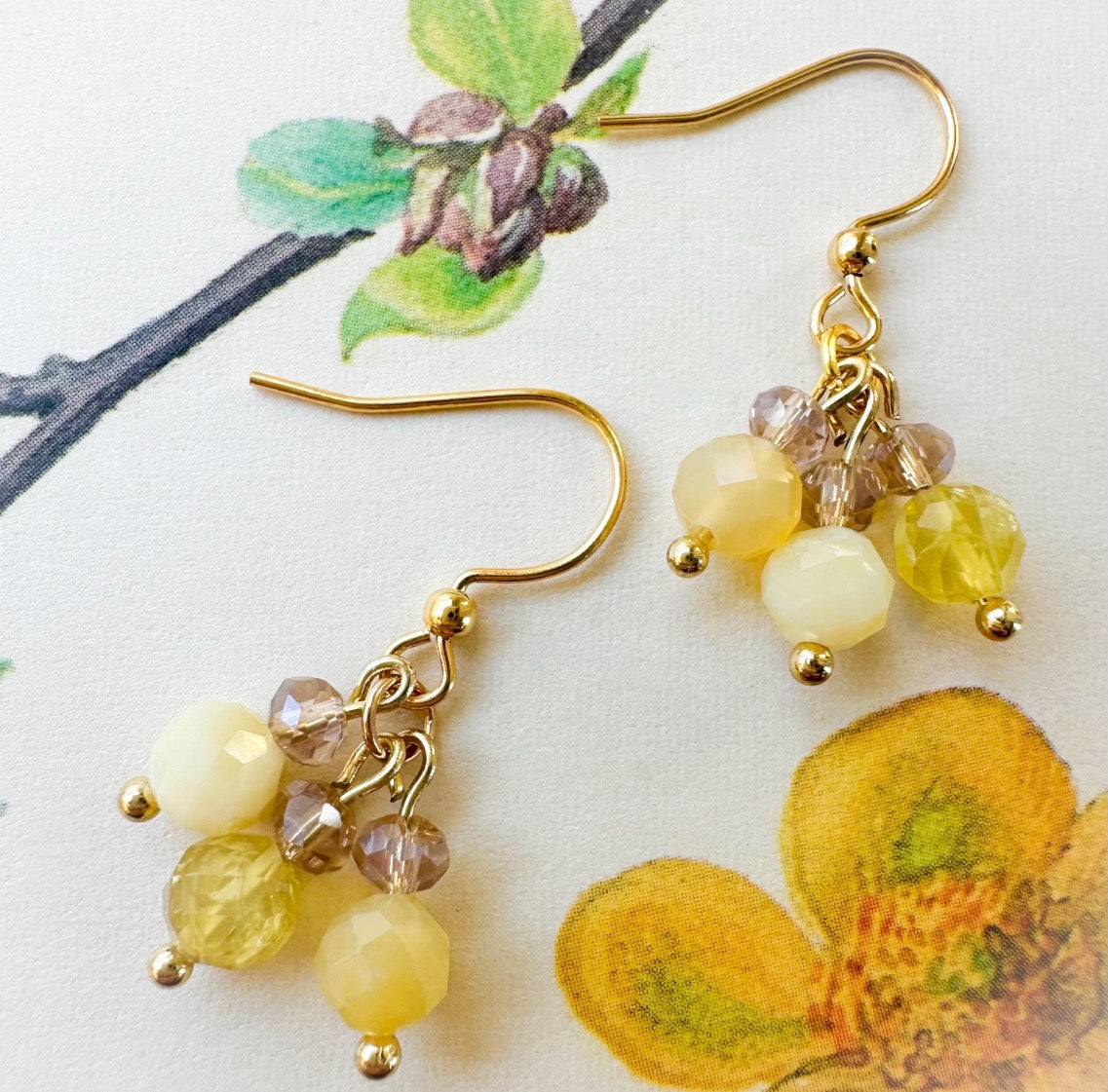 Pair of yellow beaded earrings on a floral background